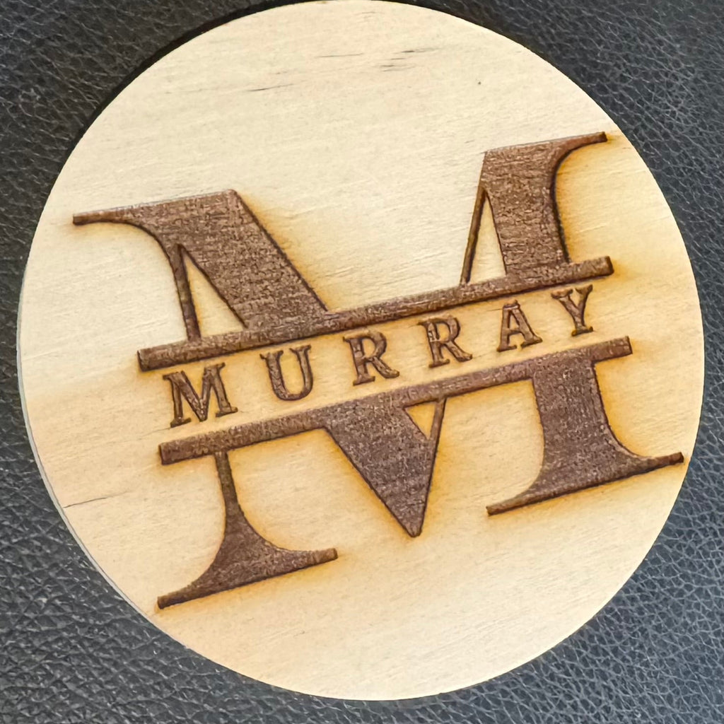 Wooden coaster with 'Murray' engraving inside of a Monogram M