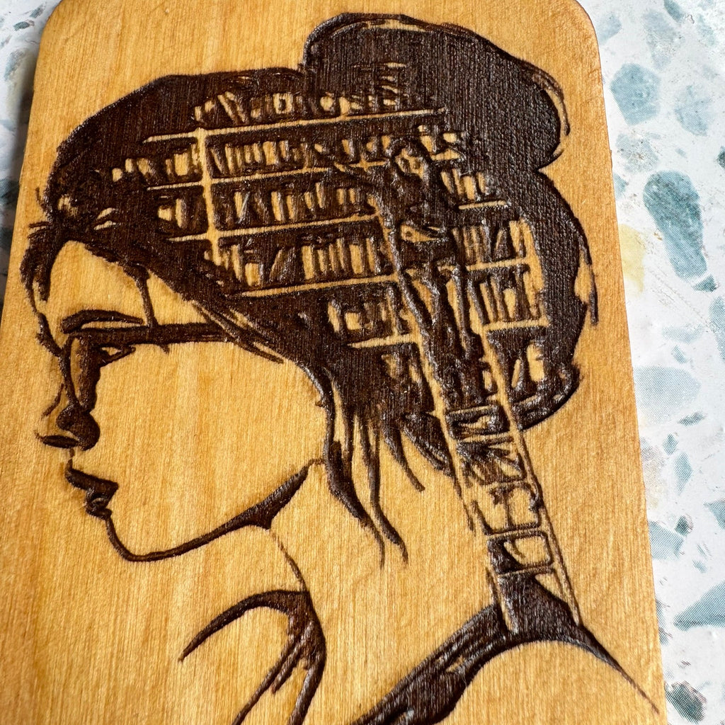 6-inch hand-burned wooden paddle featuring a woman with a bookshelf in her hair — a perfect handmade gift for book lovers, teachers, or literary decor fans.