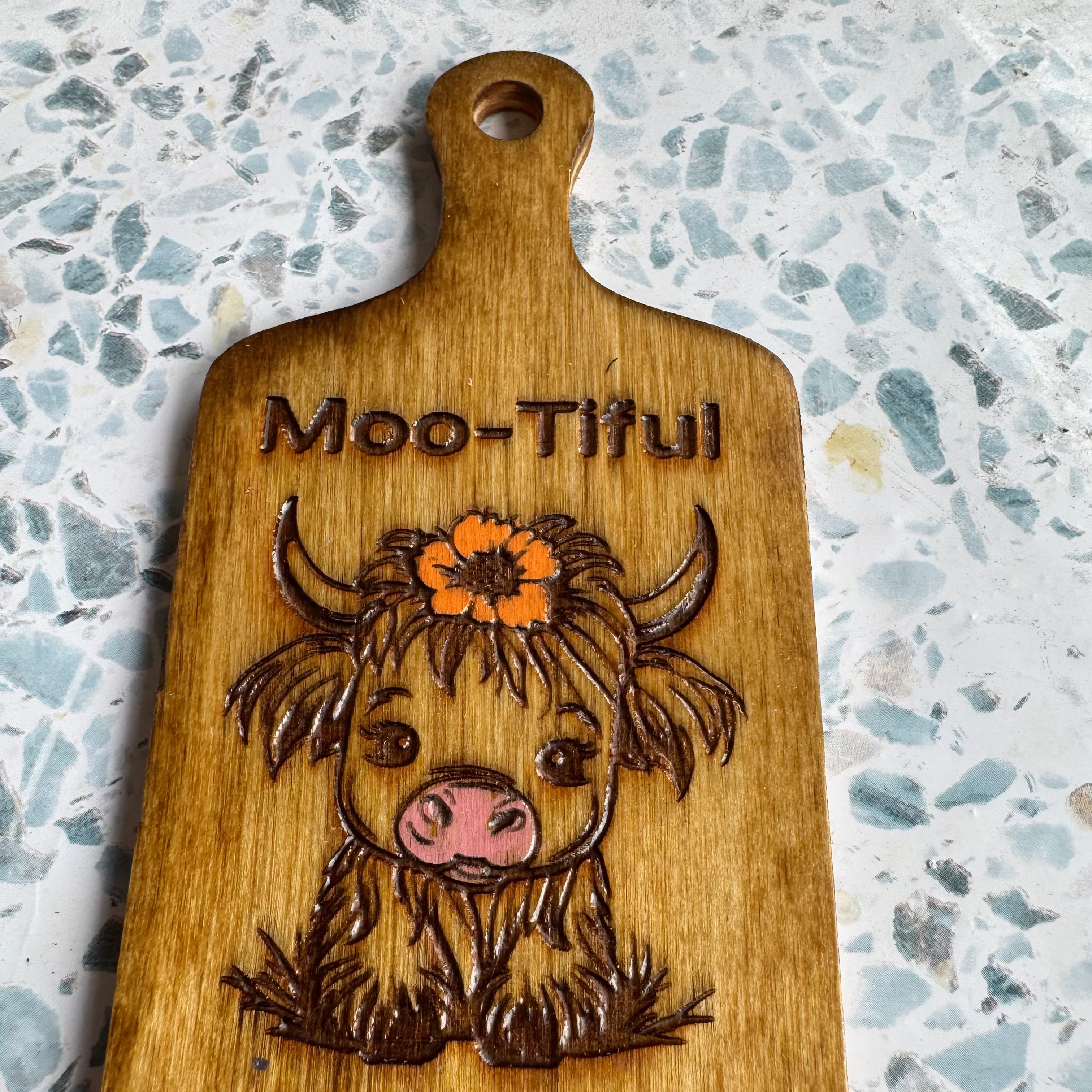 Hand-Stained 6” Wooden Paddle – Sitting Highland Cow with Hand-Painted Flower and “Moo-tiful”