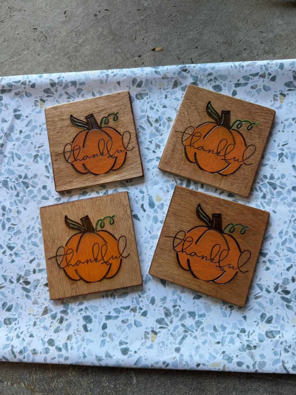 Set of 4 hand-painted wood coasters with engraved thankful pumpkin design